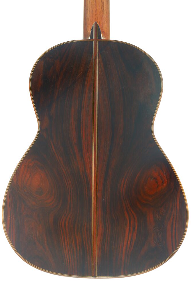 Die Rückseite der Juan Lopez Aguilarte 1984 Negra Flamenco-Gitarre ist aus dunklem Holz gefertigt und mit einer glänzenden Lackierung versehen, die die satten, natürlichen Maserungen des Holzes sowie eine zarte, schmale Mittelnaht zur Geltung bringt. Die Rückseite der Juan Lopez Aguilarte 1984 Negra Flamenco-Gitarre ist aus dunklem Holz gefertigt und mit einer glänzenden Lackierung versehen, die die satten, natürlichen Maserungen des Holzes sowie eine zarte, schmale Mittelnaht zur Geltung bringt.