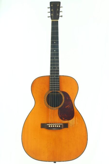 Eine Martin 00-18 Akustikgitarre aus dem Jahr 1953 mit hellem Korpus, dunklem Griffbrett und einem Schlagbrett in Schildpattoptik, fotografiert vor einem schlichten weißen Hintergrund.