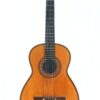Die „Salvador Ibanez 1905 Klassische Gitarre“ ist eine klassische Akustikgitarre mit einem Holzkorpus, einem dunklen Griffbrett und sechs Saiten, die vor einem schlichten weißen Hintergrund abgebildet ist.