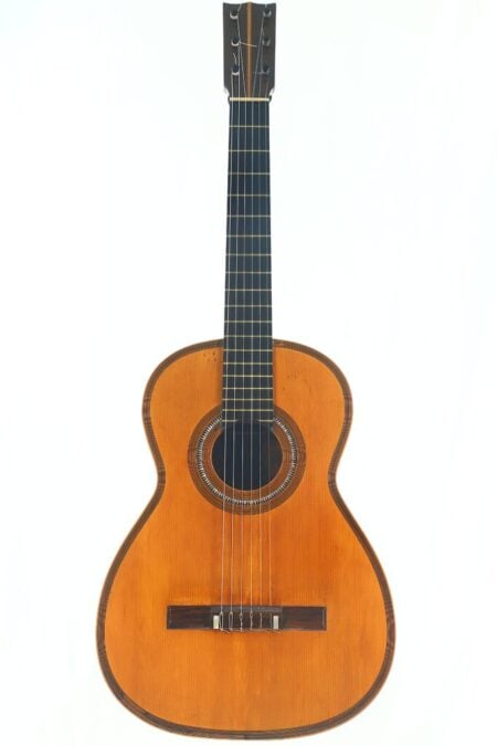 Die „Salvador Ibanez 1905 Klassische Gitarre“ ist eine klassische Akustikgitarre mit einem Holzkorpus, einem dunklen Griffbrett und sechs Saiten, die vor einem schlichten weißen Hintergrund abgebildet ist.