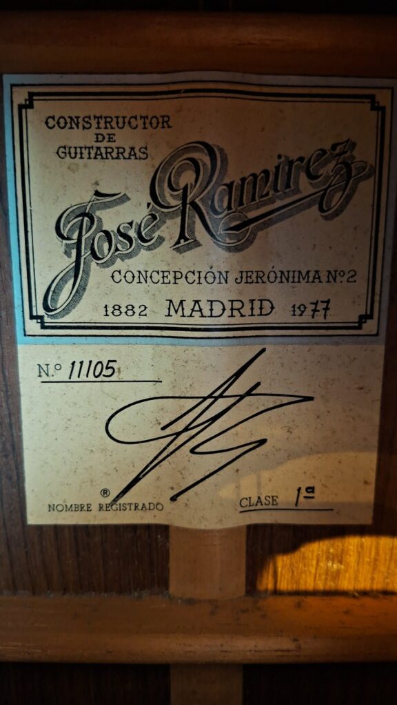 Nahaufnahme eines Gitarrenetiketts mit der Aufschrift „Jose Ramirez 1a 1977 Klassische Gitarre, Constructor de Guitarras, Concepción Jerónima Nr. 2, Madrid 1977“, mit der Seriennummer 11105 und einer Unterschrift. Nahaufnahme eines Gitarrenetiketts mit der Aufschrift „Jose Ramirez 1a 1977 Klassische Gitarre, Constructor de Guitarras, Concepción Jerónima Nr. 2, Madrid 1977“, mit der Seriennummer 11105 und einer Unterschrift.
