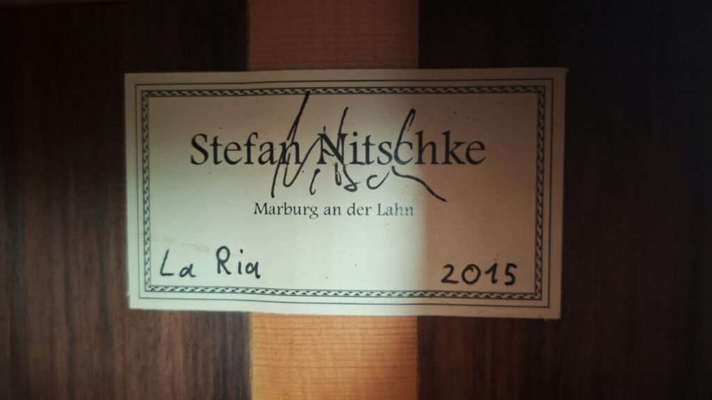 Auf dem Etikett im Inneren dieses Holzinstruments steht „Stefan Nitschke, Marburg an der Lahn, La Rio, 2015“, und über dem aufgedruckten Namen befindet sich eine Unterschrift, die es als eine „Stefan Nitschke 2015 Friederich Klassische Gitarre“ ausweist. Auf dem Etikett im Inneren dieses Holzinstruments steht „Stefan Nitschke, Marburg an der Lahn, La Rio, 2015“, und über dem aufgedruckten Namen befindet sich eine Unterschrift, die es als eine „Stefan Nitschke 2015 Friederich Klassische Gitarre“ ausweist.