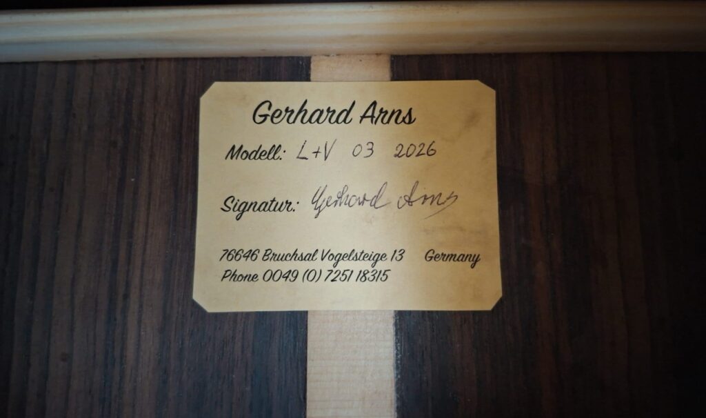 Auf einem Etikett im Inneren des Holzinstruments steht: Gerhard Arns 2026 Smallman Klassische Gitarre, Modell: L4V 03 2026, Signatur: Gerhard Arns, 76846 Bruchsal, Vogelsteige 13, Deutschland, Telefon 0049 (0) 7251/18315. Auf einem Etikett im Inneren des Holzinstruments steht: Gerhard Arns 2026 Smallman Klassische Gitarre, Modell: L4V 03 2026, Signatur: Gerhard Arns, 76846 Bruchsal, Vogelsteige 13, Deutschland, Telefon 0049 (0) 7251/18315.