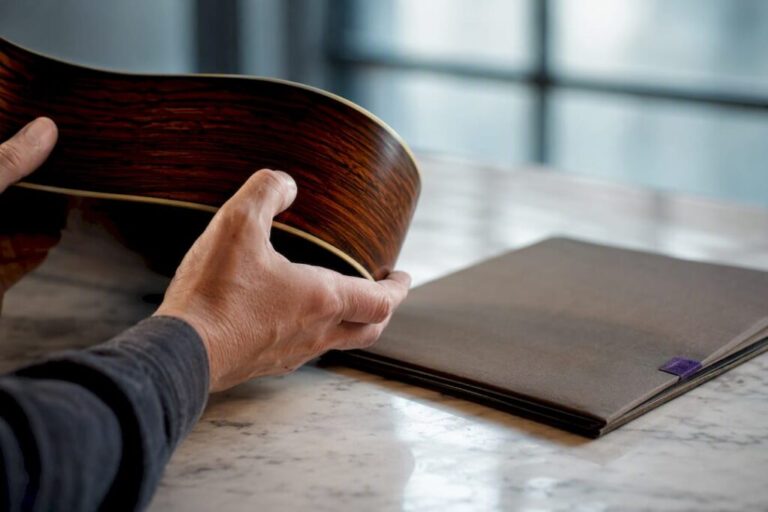 Wood verification beside guitar sale paperwork