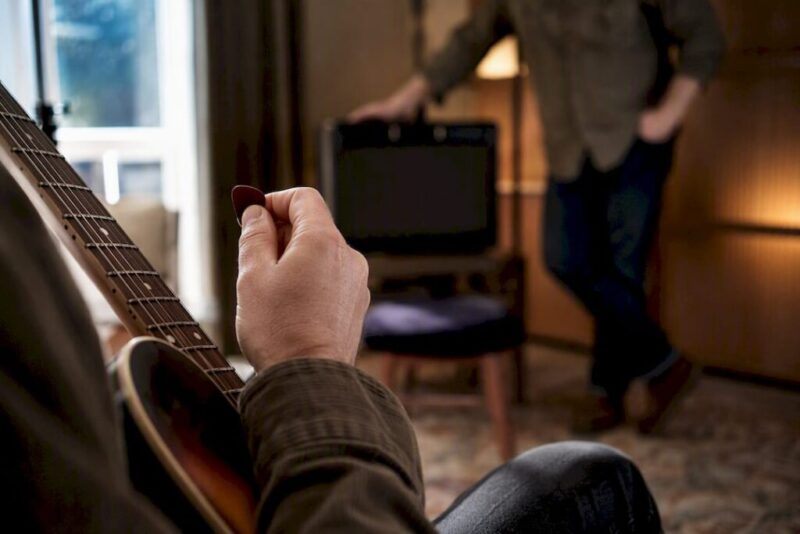 Musician testing guitar during private appointment