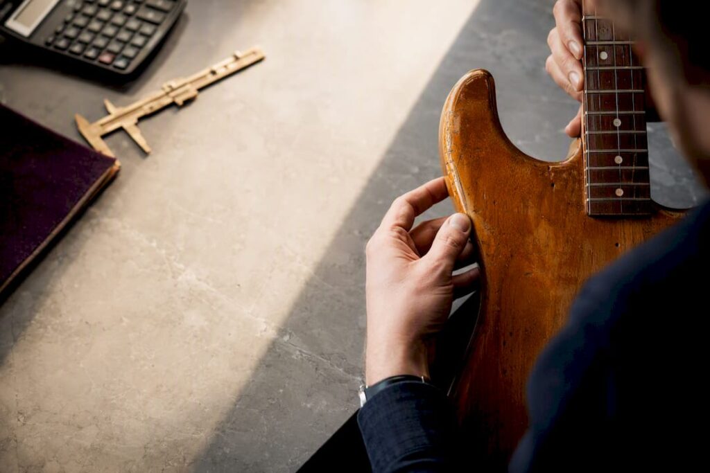Dealer inspecting guitar for consignment valuation