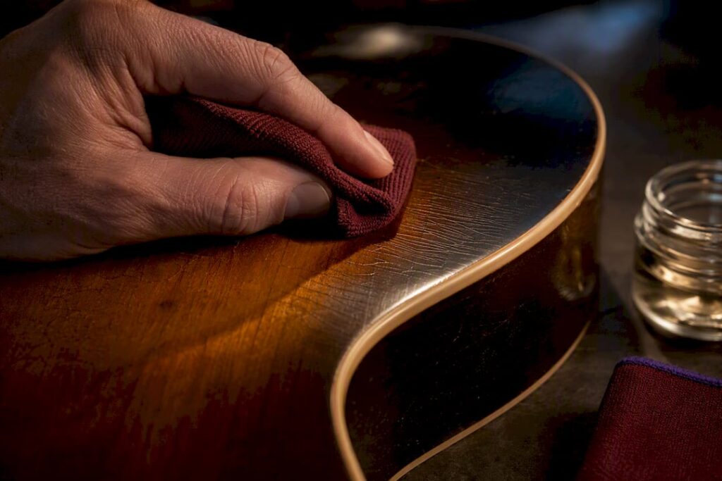 Luthier wiping shellac guitar finish