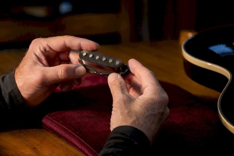 Collector inspecting an electric guitar pickup