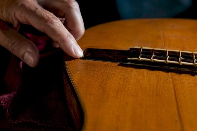 Luthier checking a vintage guitar bridge