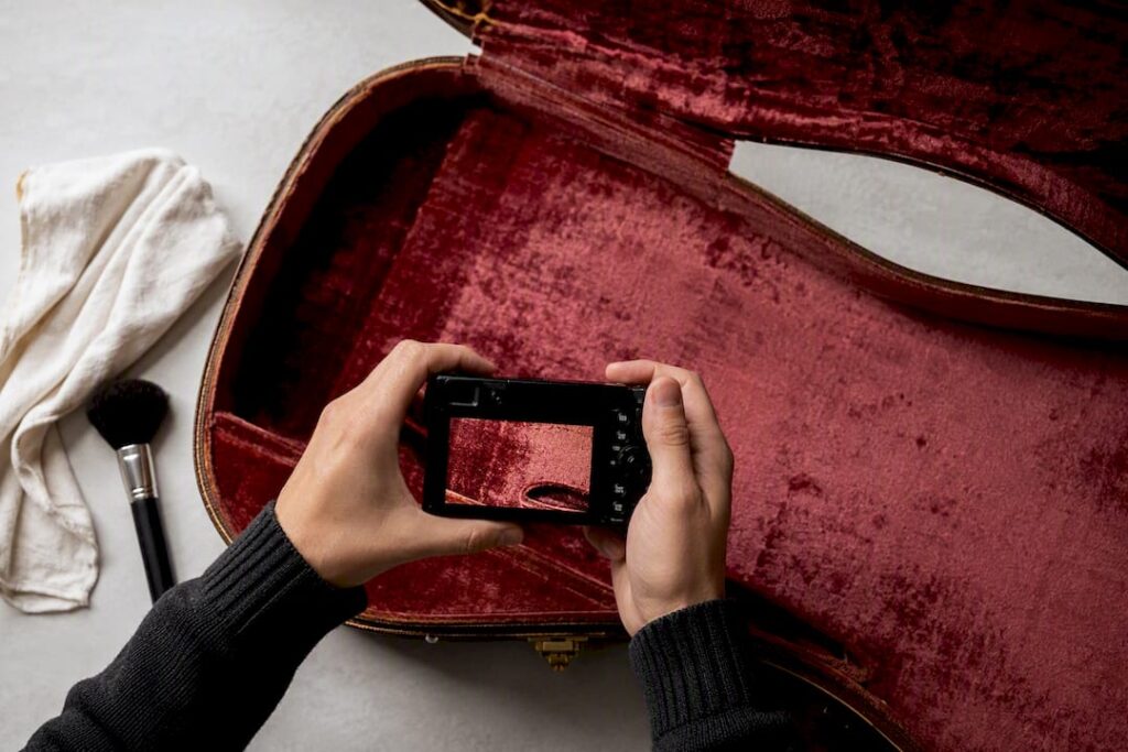 Hände fotografieren das Innenfutter eines Gitarrenkoffers