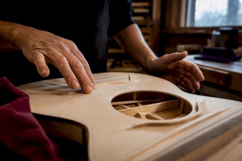 Luthier voicing guitar top and braces