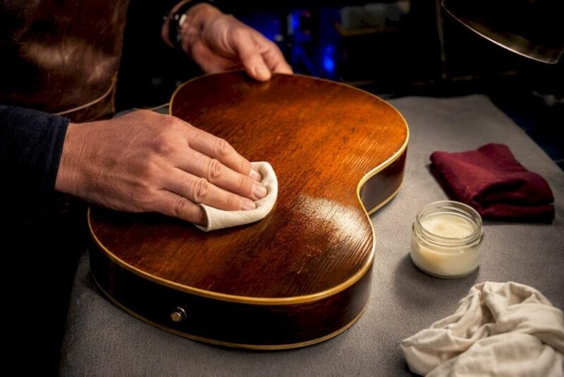 Hands polishing a vintage guitar finish