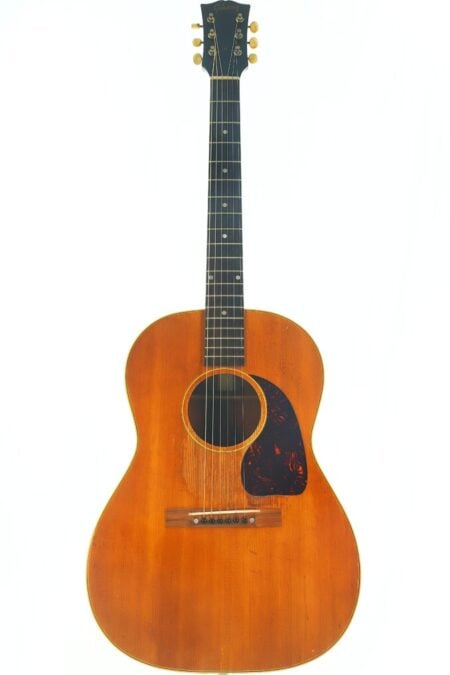 Eine Gibson LG-3 Akustik Gitarre aus dem Jahr 1954 mit einem Holzkorpus, einem dunklen Griffbrett und sechs Saiten, dargestellt vor einem weißen Hintergrund. Eine Gibson LG-3 Akustik Gitarre aus dem Jahr 1954 mit einem Holzkorpus, einem dunklen Griffbrett und sechs Saiten, dargestellt vor einem weißen Hintergrund.