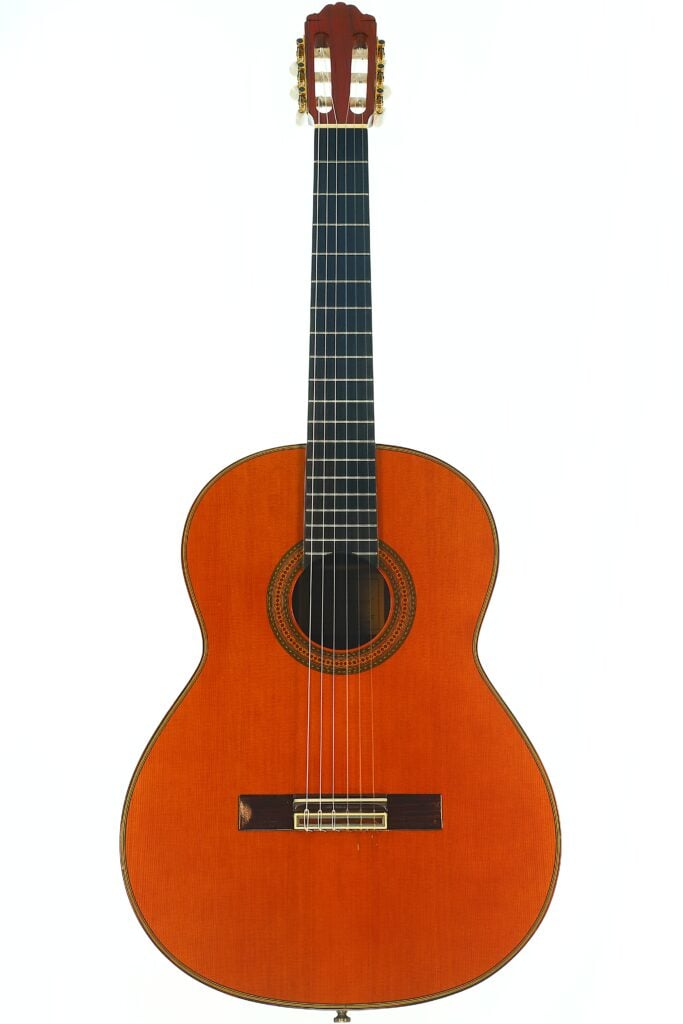 Die Paulino Bernabe M-5 2008 Klassische Gitarre ist eine klassische Akustikgitarre mit einem Holzkorpus, sechs Saiten und einer dekorativen Rosette um das Schallloch, abgebildet vor einem weißen Hintergrund. Die Paulino Bernabe M-5 2008 Klassische Gitarre ist eine klassische Akustikgitarre mit einem Holzkorpus, sechs Saiten und einer dekorativen Rosette um das Schallloch, abgebildet vor einem weißen Hintergrund.