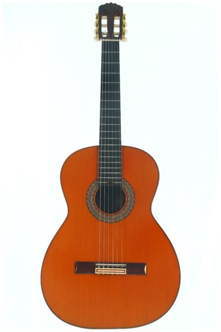 Die Conde Hermanos 1977 Negra Flamenco Gitarre ist eine klassische Akustikgitarre mit einem Holzkorpus, sechs Saiten, einem dunklen Griffbrett und einer verzierten Rosette, die das Schallloch umgibt, dargestellt vor einem schlichten weißen Hintergrund. Die Conde Hermanos 1977 Negra Flamenco Gitarre ist eine klassische Akustikgitarre mit einem Holzkorpus, sechs Saiten, einem dunklen Griffbrett und einer verzierten Rosette, die das Schallloch umgibt, dargestellt vor einem schlichten weißen Hintergrund.