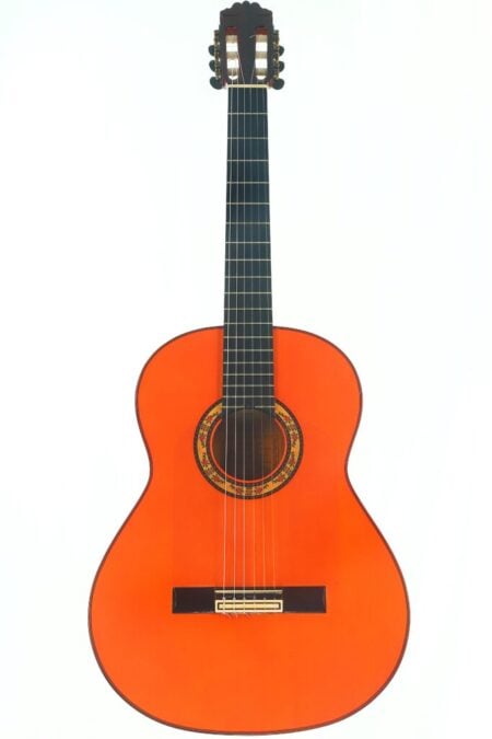 Eine Ricardo Sanchis Carpio 2002 1a F Extra Flamenco-Gitarre mit leuchtend orangefarbener Lackierung, sechs Saiten, einem verzierten Schallloch und einem dunklen Griffbrett ist vor einem schlichten weißen Hintergrund abgebildet. Eine Ricardo Sanchis Carpio 2002 1a F Extra Flamenco-Gitarre mit leuchtend orangefarbener Lackierung, sechs Saiten, einem verzierten Schallloch und einem dunklen Griffbrett ist vor einem schlichten weißen Hintergrund abgebildet.