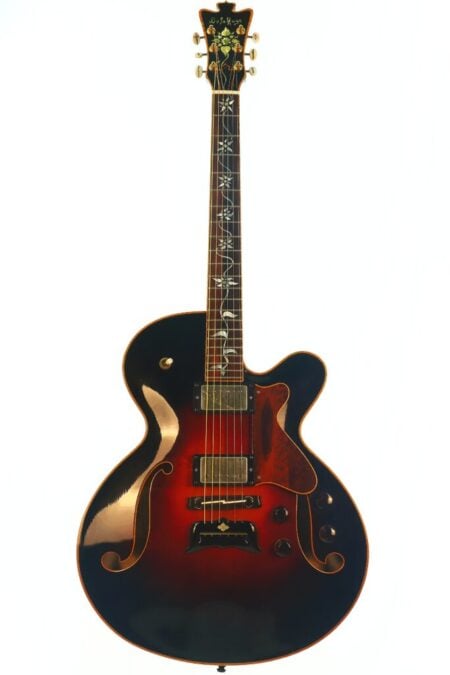 Die DeLaHaye 1995 Elektro-Akustik-Gitarre ist eine Hollow-Body-E-Gitarre im Sunburst-Look mit F-Löchern, zwei Humbucker-Tonabnehmern, dekorativen Griffbrett-Einlagen und goldfarbener Hardware, die vor einem weißen Hintergrund abgebildet ist. Die DeLaHaye 1995 Elektro-Akustik-Gitarre ist eine Hollow-Body-E-Gitarre im Sunburst-Look mit F-Löchern, zwei Humbucker-Tonabnehmern, dekorativen Griffbrett-Einlagen und goldfarbener Hardware, die vor einem weißen Hintergrund abgebildet ist.