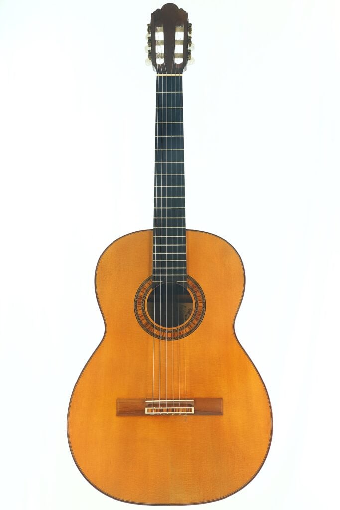 Die „Frank-Peter Dietrich 1998 Tosca Klassische Gitarre“, eine klassische Akustikgitarre mit Holzkorpus, dunklem Griffbrett und Nylonsaiten, ist vor einem weißen Hintergrund abgebildet. Die „Frank-Peter Dietrich 1998 Tosca Klassische Gitarre“, eine klassische Akustikgitarre mit Holzkorpus, dunklem Griffbrett und Nylonsaiten, ist vor einem weißen Hintergrund abgebildet.