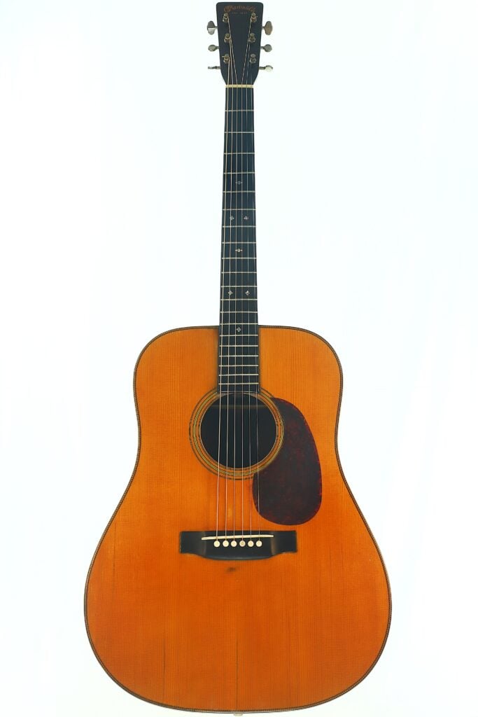 Wir präsentieren die Martin D-28 1941 Pre-War Akustik Gitarre, eine klassische Akustikgitarre mit naturbelassener Holzoberfläche, dunklem Schlagbrett, sechs Saiten und Punkt-Einlagen auf dem Griffbrett, abgebildet vor einem schlichten weißen Hintergrund. Wir präsentieren die Martin D-28 1941 Pre-War Akustik Gitarre, eine klassische Akustikgitarre mit naturbelassener Holzoberfläche, dunklem Schlagbrett, sechs Saiten und Punkt-Einlagen auf dem Griffbrett, abgebildet vor einem schlichten weißen Hintergrund.