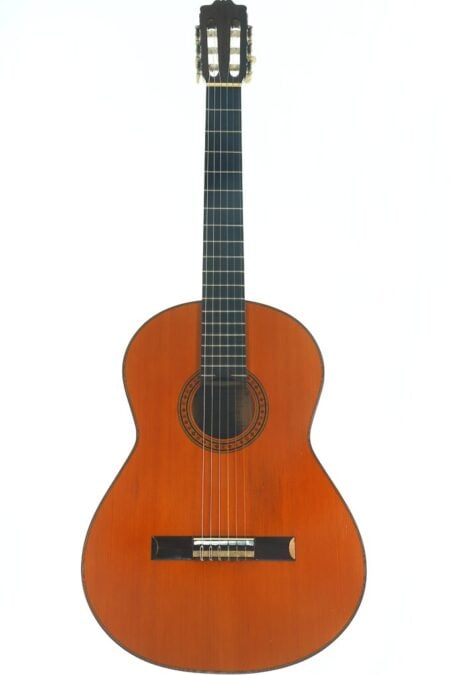 Eine Flamenco-Gitarre von Casa Arcangel Fernandez aus dem Jahr 1970 mit Holzkorpus, sechs Saiten und einem dunklen Griffbrett, fotografiert vor weißem Hintergrund. Eine Flamenco-Gitarre von Casa Arcangel Fernandez aus dem Jahr 1970 mit Holzkorpus, sechs Saiten und einem dunklen Griffbrett, fotografiert vor weißem Hintergrund.