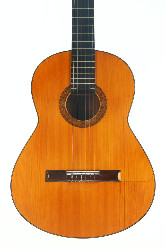 Die Flamenco-Gitarre „Francisco Barba 1966“ mit Holzkorpus und dunklem Griffbrett ist vor weißem Hintergrund abgebildet. Diese klassische Gitarre verfügt über sechs Saiten und eine dekorative Rosette um das Schallloch. Die Flamenco-Gitarre „Francisco Barba 1966“ mit Holzkorpus und dunklem Griffbrett ist vor weißem Hintergrund abgebildet. Diese klassische Gitarre verfügt über sechs Saiten und eine dekorative Rosette um das Schallloch.