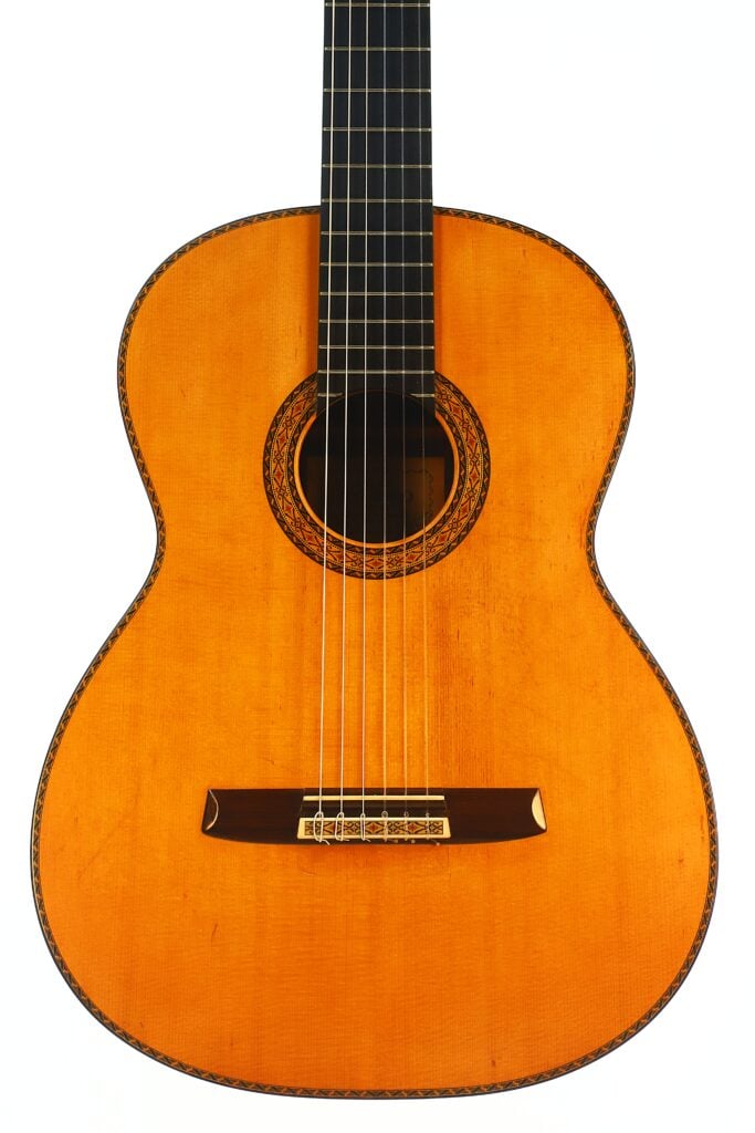 Die „Masaru Kohno Modell 50 1979 Klassische Gitarre“ ist eine klassische Akustikgitarre mit einem hellbraunen Holzkorpus, sechs Saiten und einer dekorativen Rosette, die das Schallloch umgibt und vor einem weißen Hintergrund zu sehen ist. Die „Masaru Kohno Modell 50 1979 Klassische Gitarre“ ist eine klassische Akustikgitarre mit einem hellbraunen Holzkorpus, sechs Saiten und einer dekorativen Rosette, die das Schallloch umgibt und vor einem weißen Hintergrund zu sehen ist.