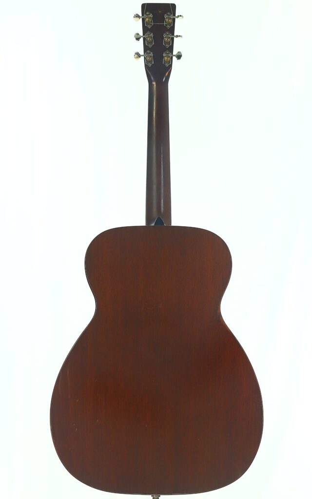 Das Bild zeigt die Rückansicht der Martin 00-17 Akustikgitarre aus dem Jahr 1941 und verdeutlicht dabei ihre dunkle Holzoberfläche, die Stimmwirbel sowie den geschmeidig geschwungenen Korpus. Das Bild zeigt die Rückansicht der Martin 00-17 Akustikgitarre aus dem Jahr 1941 und verdeutlicht dabei ihre dunkle Holzoberfläche, die Stimmwirbel sowie den geschmeidig geschwungenen Korpus.