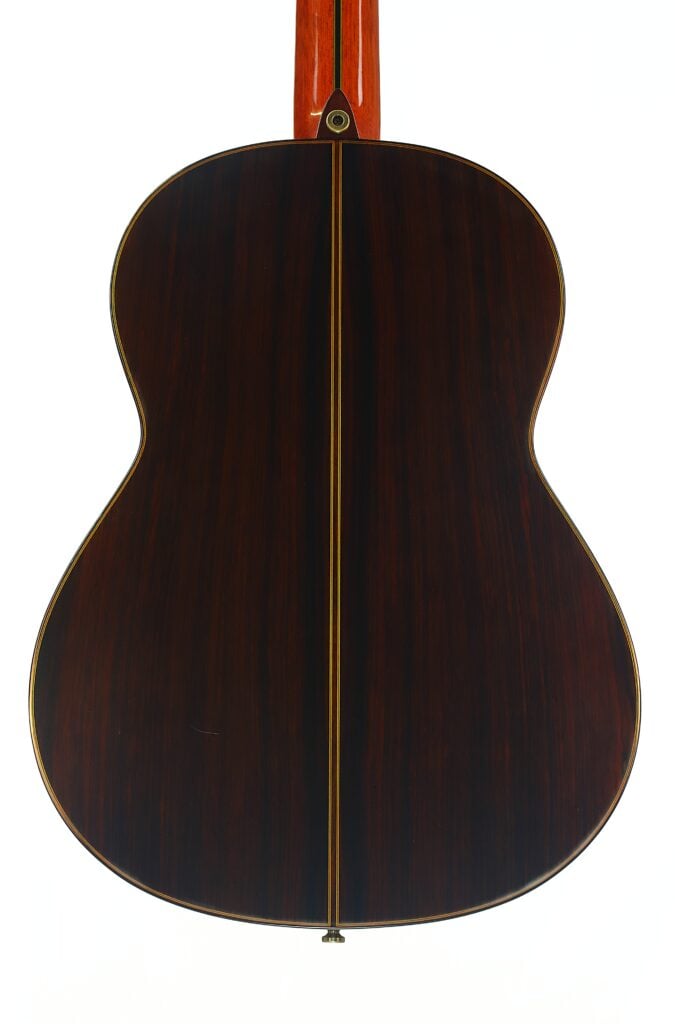 Rückansicht der Paulino Bernabe M-5 2008 Klassische Gitarre mit dunkler Holzoberfläche, hellem Mittelstreifen und rötlichem Hals, abgebildet vor einem schlichten weißen Hintergrund. Rückansicht der Paulino Bernabe M-5 2008 Klassische Gitarre mit dunkler Holzoberfläche, hellem Mittelstreifen und rötlichem Hals, abgebildet vor einem schlichten weißen Hintergrund.