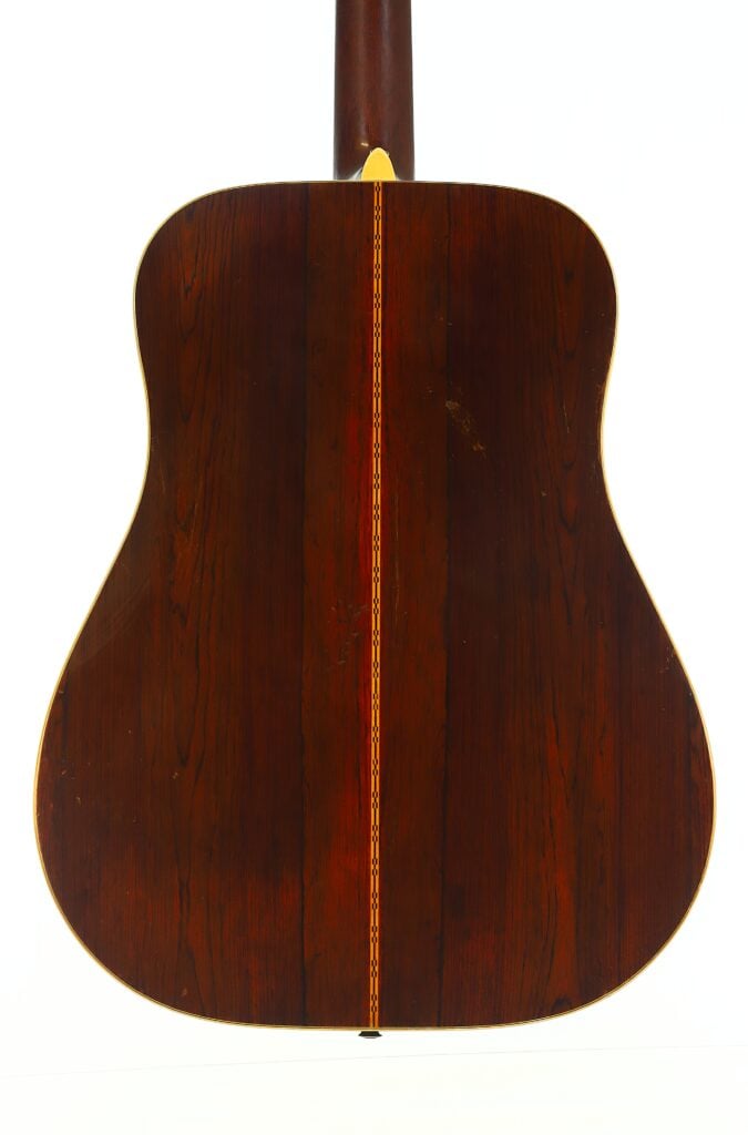 Die Rückseite der Martin D-28 Akustikgitarre aus dem Jahr 1965, die sich durch dunkles Holz mit glänzender Oberfläche und einer dekorativen Einlage in der Mitte auszeichnet. Der Hintergrund ist reinweiß. Die Rückseite der Martin D-28 Akustikgitarre aus dem Jahr 1965, die sich durch dunkles Holz mit glänzender Oberfläche und einer dekorativen Einlage in der Mitte auszeichnet. Der Hintergrund ist reinweiß.