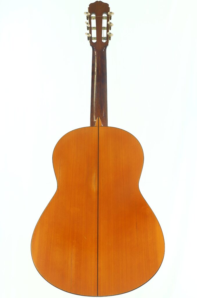 Rückansicht der Francisco Barba Flamenco-Gitarre von 1966 mit einem naturbelassenen Holzkorpus und einem dunklen Hals mit Stimmwirbeln. Rückansicht der Francisco Barba Flamenco-Gitarre von 1966 mit einem naturbelassenen Holzkorpus und einem dunklen Hals mit Stimmwirbeln.