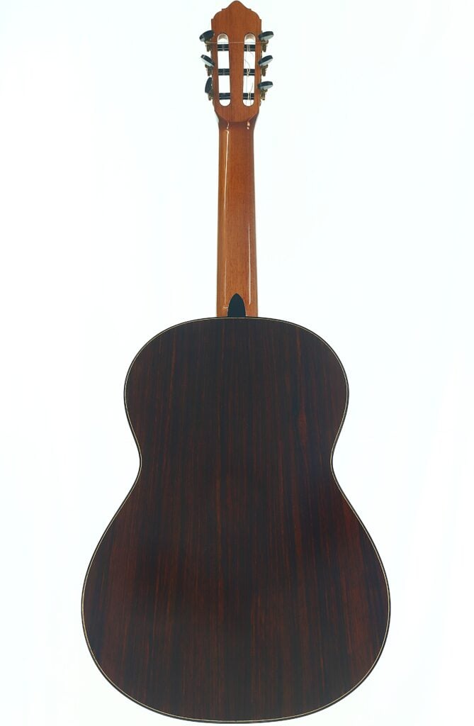 Die Lester DeVoe 2020 Negra Flamenco-Gitarre ist von hinten fotografiert, wobei ihr dunkler Holzkorpus, der helle Hals und die Stimmwirbel am Kopf vor einem weißen Hintergrund besonders gut zur Geltung kommen. Die Lester DeVoe 2020 Negra Flamenco-Gitarre ist von hinten fotografiert, wobei ihr dunkler Holzkorpus, der helle Hals und die Stimmwirbel am Kopf vor einem weißen Hintergrund besonders gut zur Geltung kommen.