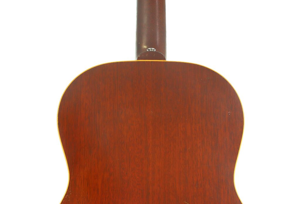 Das Bild zeigt die Rückansicht einer Gibson LG-3 Akustikgitarre aus dem Jahr 1954 und hebt dabei den Holzkorpus und den Hals mit ihrer rotbraunen Lackierung hervor. Das Bild zeigt die Rückansicht einer Gibson LG-3 Akustikgitarre aus dem Jahr 1954 und hebt dabei den Holzkorpus und den Hals mit ihrer rotbraunen Lackierung hervor.