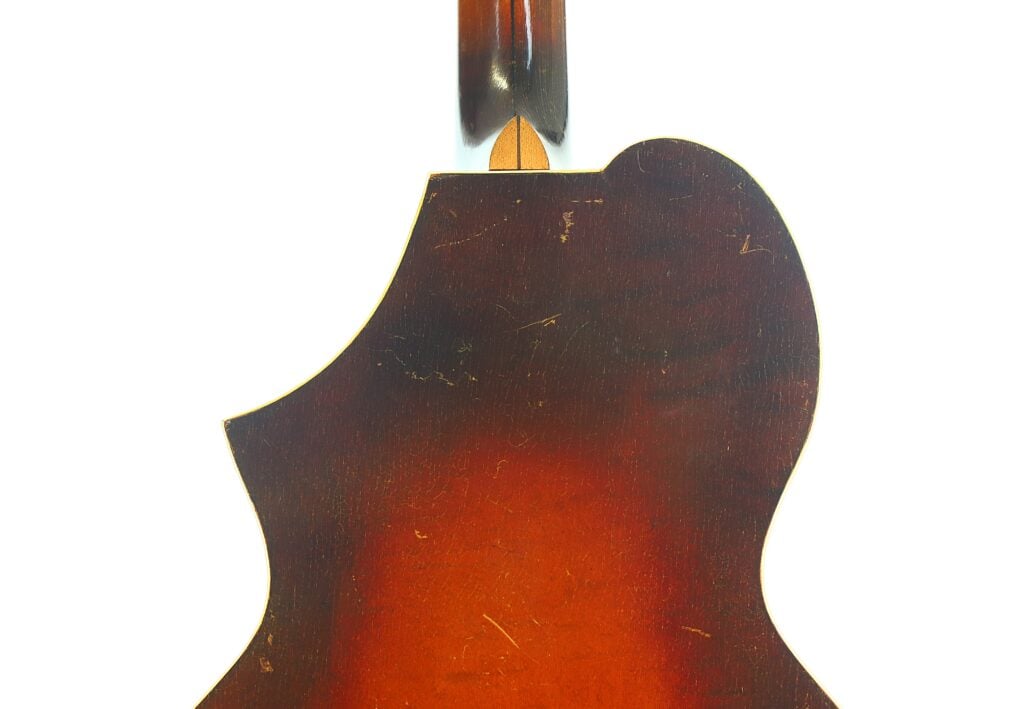 Nahaufnahme des oberen Rückenteils einer Epiphone Recording B 1931 Akustikgitarre mit Sunburst-Lackierung und dem Halsansatz vor weißem Hintergrund. Nahaufnahme des oberen Rückenteils einer Epiphone Recording B 1931 Akustikgitarre mit Sunburst-Lackierung und dem Halsansatz vor weißem Hintergrund.