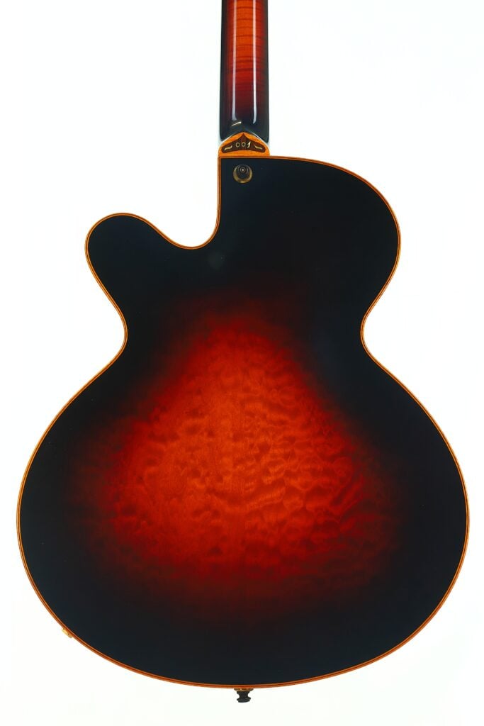 Eine DeLaHaye 1995 Elektro-Akustik-Gitarre in der Draufsicht, mit einem Boden in Sunburst-Optik und einer gesteppten Holzstruktur, einem abgerundeten Korpus und einem Single-Cutaway, vor weißem Hintergrund. Eine DeLaHaye 1995 Elektro-Akustik-Gitarre in der Draufsicht, mit einem Boden in Sunburst-Optik und einer gesteppten Holzstruktur, einem abgerundeten Korpus und einem Single-Cutaway, vor weißem Hintergrund.