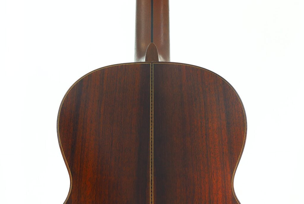Die Rückseite der „Tosca Klassische Gitarre“ von Frank-Peter Dietrich aus dem Jahr 1998, die aus dunklem Holz gefertigt ist, wurde von hinten im Hochformat fotografiert, um die Maserung des Holzes und die Mittelnaht hervorzuheben. Die Rückseite der „Tosca Klassische Gitarre“ von Frank-Peter Dietrich aus dem Jahr 1998, die aus dunklem Holz gefertigt ist, wurde von hinten im Hochformat fotografiert, um die Maserung des Holzes und die Mittelnaht hervorzuheben.