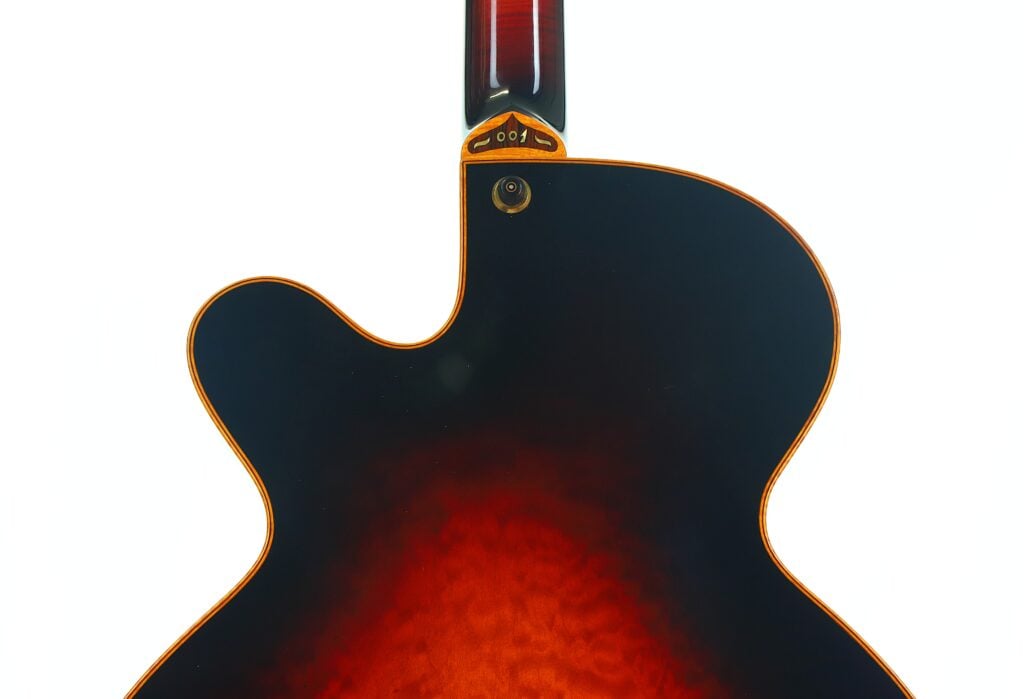 Nahaufnahme der Rückseite einer DeLaHaye Elektro-Akustik-Gitarre aus dem Jahr 1995 mit Sunburst-Lackierung vor weißem Hintergrund, wobei der Cutaway und der Halsansatz besonders hervorgehoben sind. Nahaufnahme der Rückseite einer DeLaHaye Elektro-Akustik-Gitarre aus dem Jahr 1995 mit Sunburst-Lackierung vor weißem Hintergrund, wobei der Cutaway und der Halsansatz besonders hervorgehoben sind.