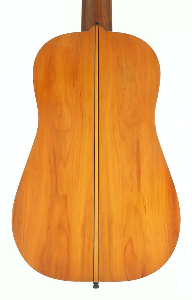 Rückansicht der Vihuela von Hans Herb aus dem Jahr 1989 mit einer glatten, polierten Holzoberfläche, auf der die Maserung sichtbar ist und die in der Mitte von einer dunklen Linie vertikal durchzogen wird. Rückansicht der Vihuela von Hans Herb aus dem Jahr 1989 mit einer glatten, polierten Holzoberfläche, auf der die Maserung sichtbar ist und die in der Mitte von einer dunklen Linie vertikal durchzogen wird.