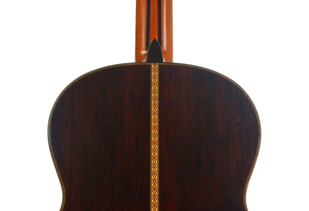 Die Rückseite der „Masaru Kohno Modell 50 1979“ Klassische Gitarre aus dunklem Holz mit einer dekorativen vertikalen Einlage in der Mitte und einem Teil des Halses, der oben zu sehen ist. Die Rückseite der „Masaru Kohno Modell 50 1979“ Klassische Gitarre aus dunklem Holz mit einer dekorativen vertikalen Einlage in der Mitte und einem Teil des Halses, der oben zu sehen ist.