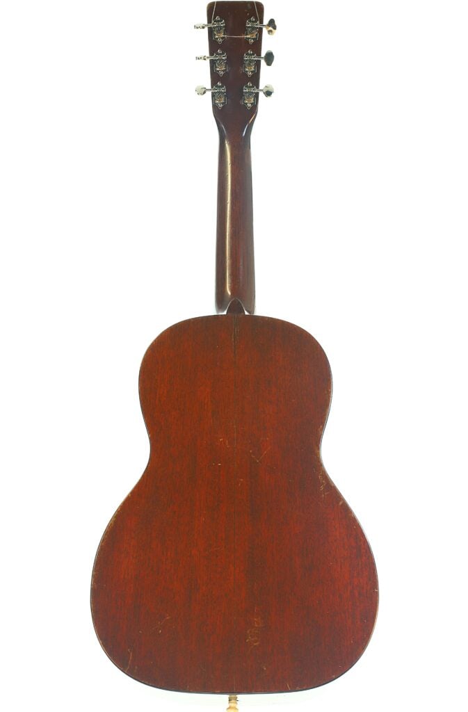 Rückansicht einer Martin 5-18 Akustikgitarre aus dem Jahr 1958 mit dunkler Holzoberfläche, auf der der Hals, die Stimmwirbel und der Korpus vor einem weißen Hintergrund zu sehen sind. Rückansicht einer Martin 5-18 Akustikgitarre aus dem Jahr 1958 mit dunkler Holzoberfläche, auf der der Hals, die Stimmwirbel und der Korpus vor einem weißen Hintergrund zu sehen sind.