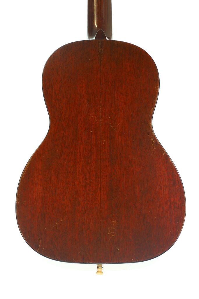 Die Rückseite einer Martin 5-18 Akustikgitarre aus dem Jahr 1958 mit dunkler Holzoberfläche ist vor einem weißen Hintergrund fotografiert. Die Maserung und die Struktur des Holzes sind deutlich zu erkennen. Die Rückseite einer Martin 5-18 Akustikgitarre aus dem Jahr 1958 mit dunkler Holzoberfläche ist vor einem weißen Hintergrund fotografiert. Die Maserung und die Struktur des Holzes sind deutlich zu erkennen.