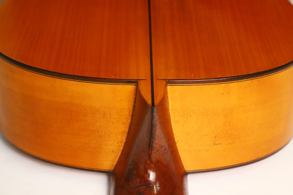 Nahaufnahme der Rückseite einer Francisco-Barba-Flamenco-Gitarre aus dem Jahr 1966, die die Verbindungsstelle zwischen Hals und Korpus zeigt. Das Holz hat eine warme, braune Oberfläche und eine sichtbare Maserung. Nahaufnahme der Rückseite einer Francisco-Barba-Flamenco-Gitarre aus dem Jahr 1966, die die Verbindungsstelle zwischen Hals und Korpus zeigt. Das Holz hat eine warme, braune Oberfläche und eine sichtbare Maserung.