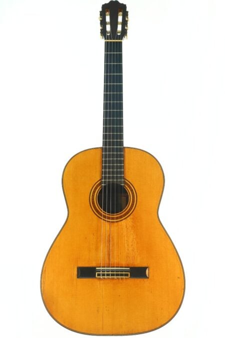 Die Angel Alonso 1936 Klassische Gitarre ist eine klassische Akustikgitarre mit naturbelassener Holzoberfläche, einem dunklen Griffbrett, sechs Saiten und einem aufwendigen Rosettenmuster, das das Schallloch umgibt und sich vor einem weißen Hintergrund abhebt. Die Angel Alonso 1936 Klassische Gitarre ist eine klassische Akustikgitarre mit naturbelassener Holzoberfläche, einem dunklen Griffbrett, sechs Saiten und einem aufwendigen Rosettenmuster, das das Schallloch umgibt und sich vor einem weißen Hintergrund abhebt.
