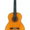 Die Hopf La Portentosa 2000 Klassiche Gitarre, eine klassische Akustikgitarre mit naturbelassenem Holzfinish, ist vor einem weißen Hintergrund abgebildet. Diese Gitarre verfügt über sechs Saiten, ein dunkles Griffbrett und dekorative Verzierungen rund um das Schallloch.