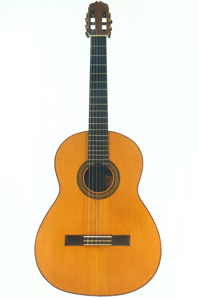 Die „Andres Martin 1966 Klassische Gitarre“ ist eine klassische Akustikgitarre mit einem Holzkorpus, sechs Saiten, einem dunklen Griffbrett und einer dekorativen Rosette um das Schallloch – ein elegantes Instrument, das wunderschön vor einem weißen Hintergrund fotografiert wurde. Die „Andres Martin 1966 Klassische Gitarre“ ist eine klassische Akustikgitarre mit einem Holzkorpus, sechs Saiten, einem dunklen Griffbrett und einer dekorativen Rosette um das Schallloch – ein elegantes Instrument, das wunderschön vor einem weißen Hintergrund fotografiert wurde.