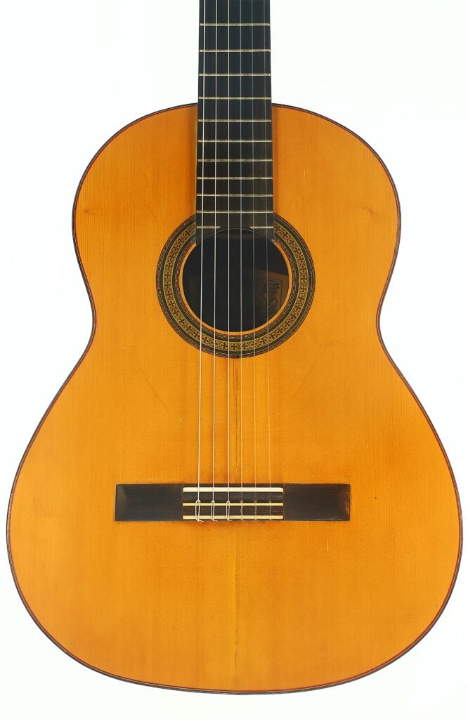 Die „Andres Martin 1966 Klassische Gitarre“ ist eine klassische Akustikgitarre mit einem Korpus aus Holz, sechs Saiten und einem verzierten Schallloch, die vor einem weißen Hintergrund abgebildet ist. Die „Andres Martin 1966 Klassische Gitarre“ ist eine klassische Akustikgitarre mit einem Korpus aus Holz, sechs Saiten und einem verzierten Schallloch, die vor einem weißen Hintergrund abgebildet ist.