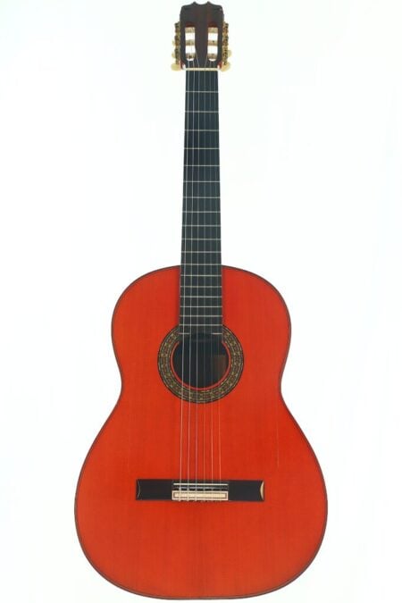 Eine Hermanos Conde 1989 Negra Flamenco Gitarre mit rotbraunem Holzkorpus, dunklem Hals und einer verzierten Rosette um das Schallloch, fotografiert vor weißem Hintergrund. Eine Hermanos Conde 1989 Negra Flamenco Gitarre mit rotbraunem Holzkorpus, dunklem Hals und einer verzierten Rosette um das Schallloch, fotografiert vor weißem Hintergrund.