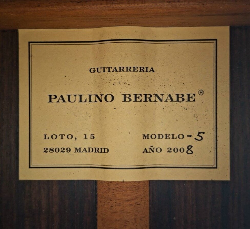 Auf einem Etikett am Holz der Paulino Bernabe M-5 2008 Klassische Gitarre steht: GUITARRERIA PAULINO BERNABE, LOTO, 15 28029 MADRID, MODELO -5, AÑO 2008. Das Etikett hat einen schwarzen Rand und schwarzen Aufdruck. Auf einem Etikett am Holz der Paulino Bernabe M-5 2008 Klassische Gitarre steht: GUITARRERIA PAULINO BERNABE, LOTO, 15 28029 MADRID, MODELO -5, AÑO 2008. Das Etikett hat einen schwarzen Rand und schwarzen Aufdruck.