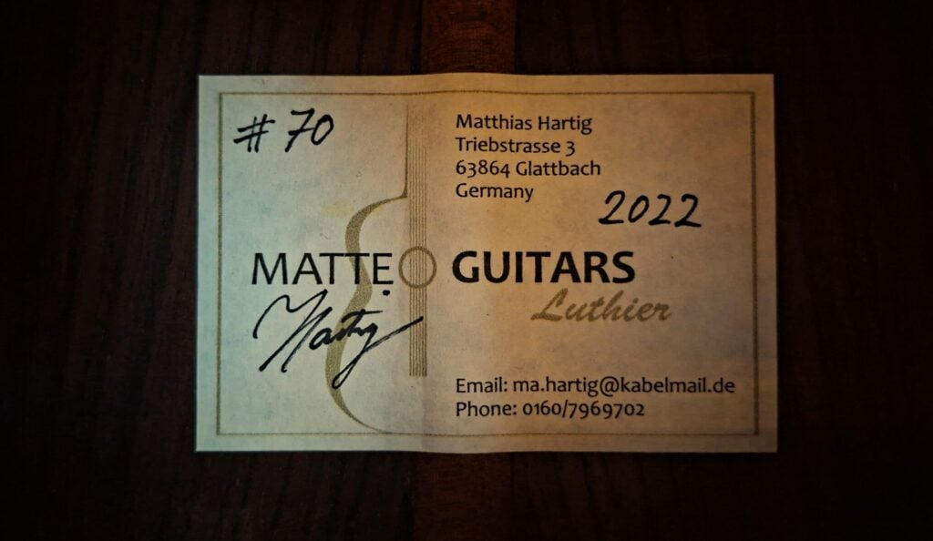 Etikett für eine Matthias Hartig 2022 Hohlkehle Klassische Gitarre, nummeriert mit der Nummer 70, signiert von Matthias Hartig (Gitarrenbauer), mit Kontaktdaten und Adresse in Glattbach, Deutschland. Etikett für eine Matthias Hartig 2022 Hohlkehle Klassische Gitarre, nummeriert mit der Nummer 70, signiert von Matthias Hartig (Gitarrenbauer), mit Kontaktdaten und Adresse in Glattbach, Deutschland.
