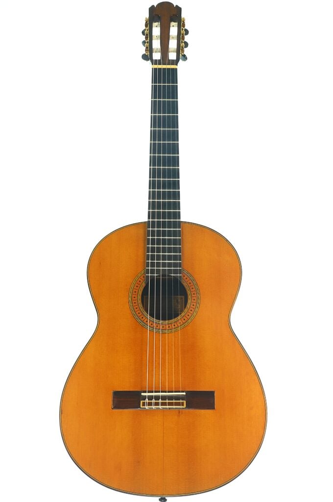 Eine klassische Gitarre von Richard Howell aus dem Jahr 1980 mit einem Korpus aus Holz, einem dunklen Griffbrett und einer dekorativen Rosette um das Schallloch. Eine klassische Gitarre von Richard Howell aus dem Jahr 1980 mit einem Korpus aus Holz, einem dunklen Griffbrett und einer dekorativen Rosette um das Schallloch.
