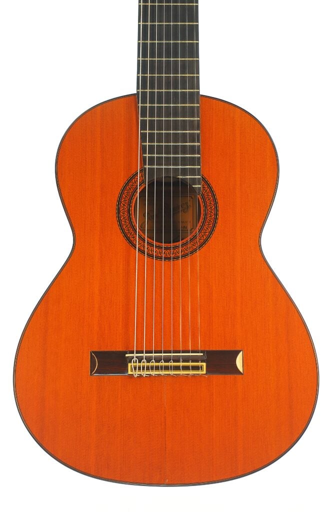 Jose Ramirez 1984, 8-saitige klassische Gitarre mit einem orangefarbenen Holzkorpus und einer verzierten Schalllochrosette. Jose Ramirez 1984, 8-saitige klassische Gitarre mit einem orangefarbenen Holzkorpus und einer verzierten Schalllochrosette.